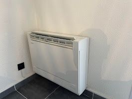 Console murale de climatisation Hitachi installée en coin de pièce blanche à L'Union par AFO Énergies, design encastrable pour espace réduit.