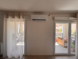 Unité intérieure de climatisation monosplit installée au-dessus d’une baie vitrée dans un salon lumineux d’un appartement à Saint-Jean, par AFO Énergies.