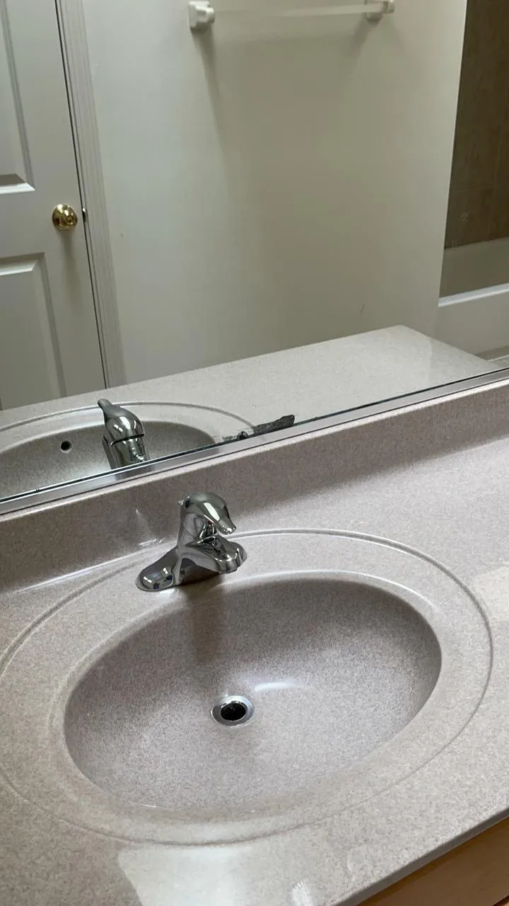 Clean and polished bathroom sink, mirror and faucet in a Woodridge home after deep cleaning.