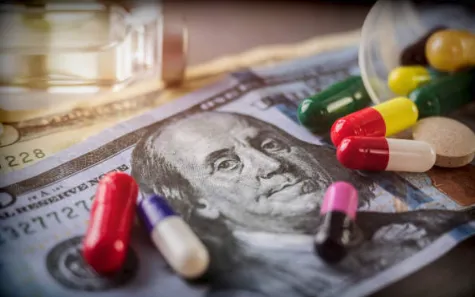 Various pills laying on paper money