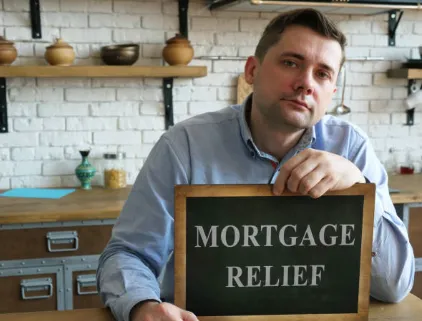 A man hold a "Mortgage relief" sign