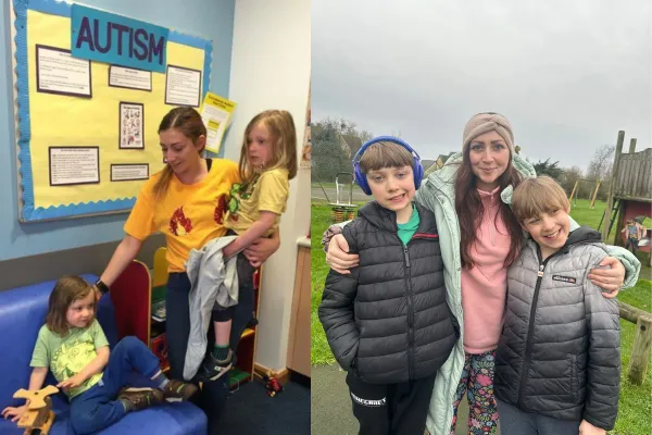 A mum with one twin on her hip and reaching down to comfort her other twin boy, with a display board in the background that says "AUTISM"