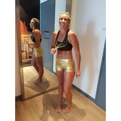 athletic woman wearing gold hot pants