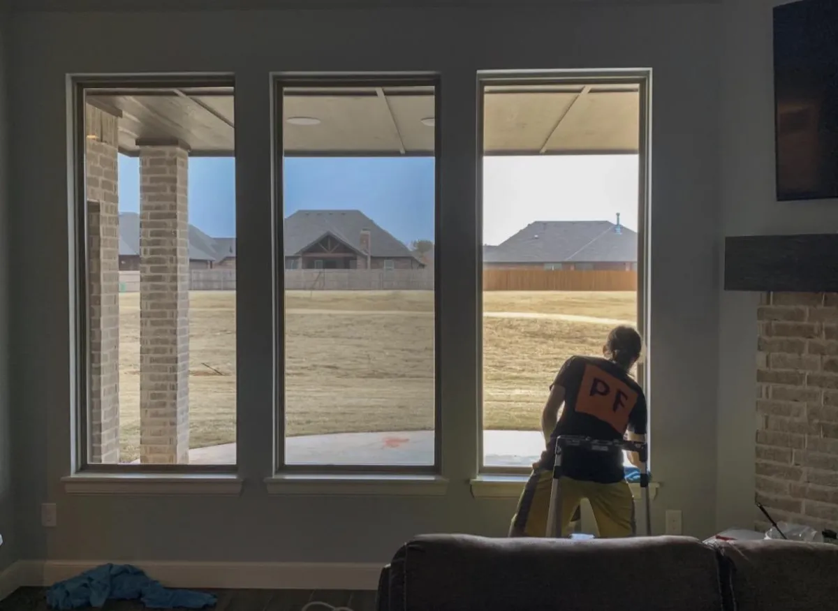 Professional installer applying window film to living room windows