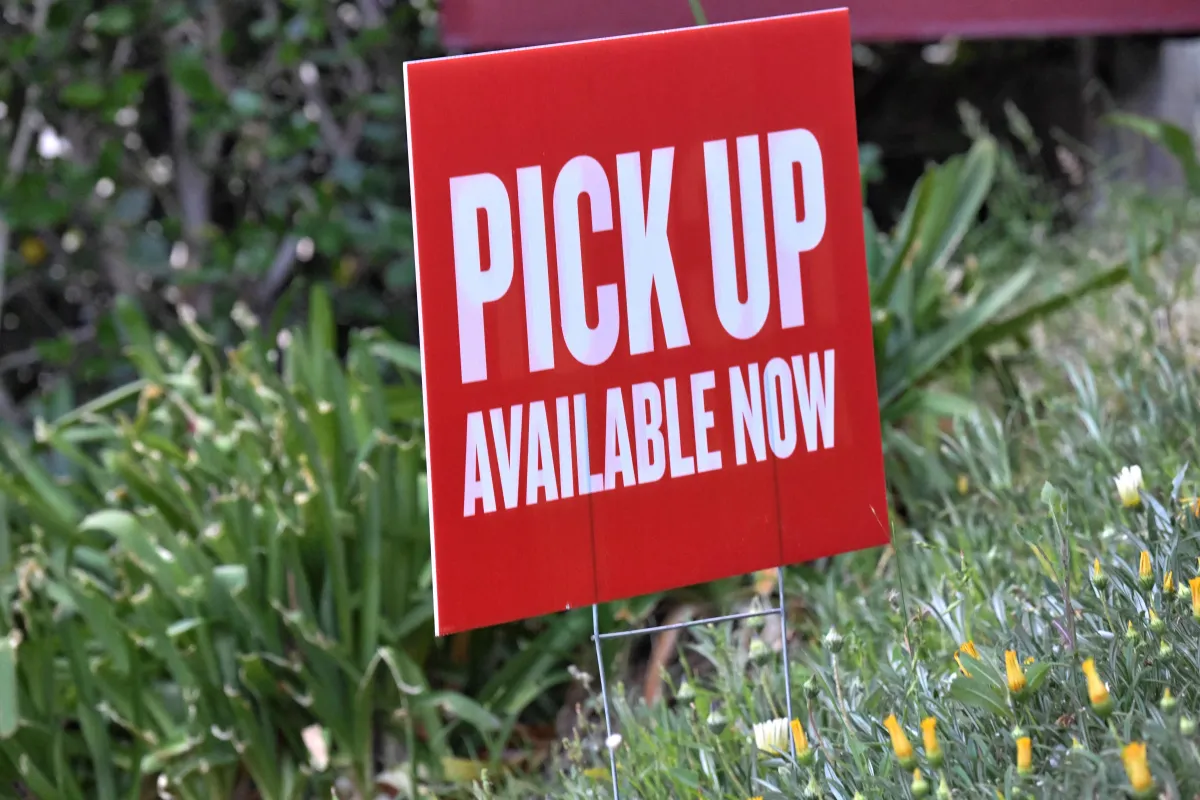 Custom printed yard sign for event or product pickup promotion placed on grass