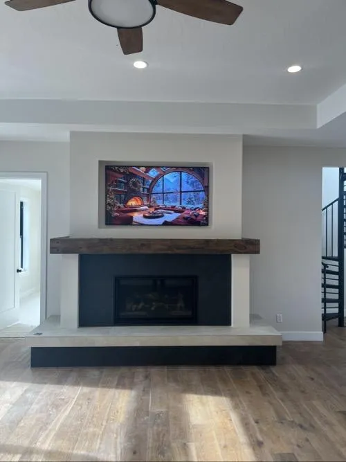 mounted TV above displaying a cozy cabin scene
