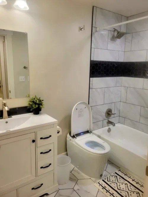 Bathroom remodel with vanity, tile shower, and modern fixtures.