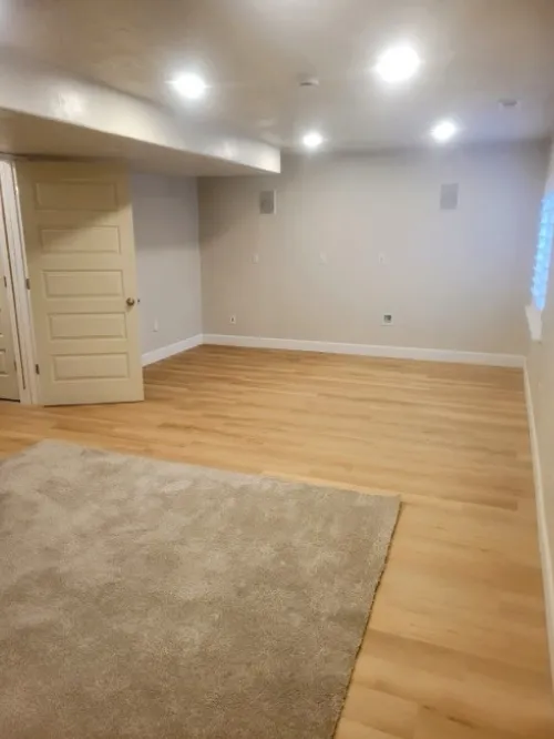 Basement remodel with wood flooring and recessed lighting.