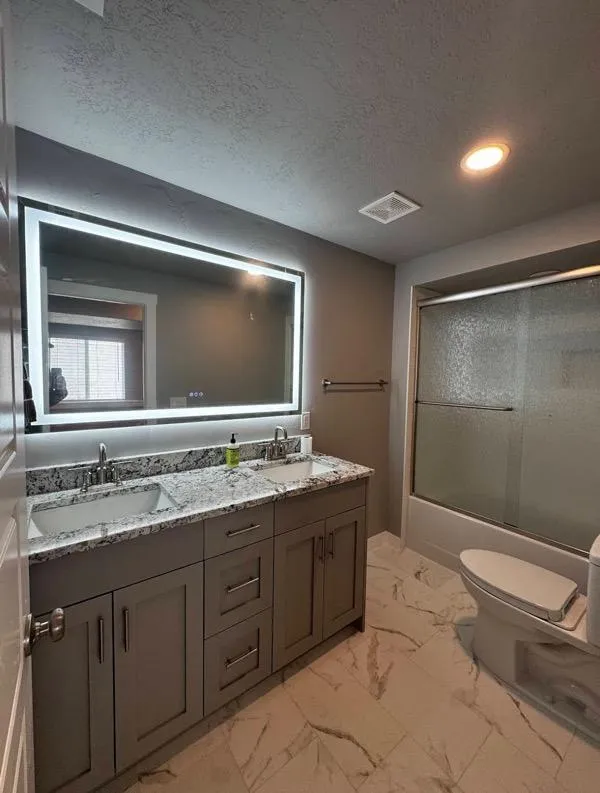Stylish bathroom remodel with double vanity and LED mirror in Layton UT
