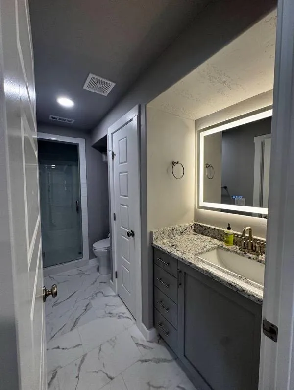 Modern bathroom remodel with granite vanity and glass shower in Layton UT