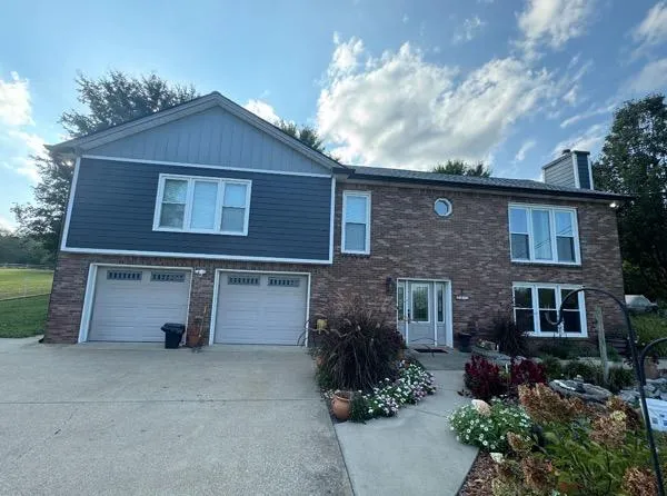Two-story brick home with new dark Hardie siding accent in Spring Hill, Tennessee