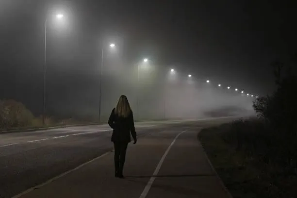woman walking down dark street