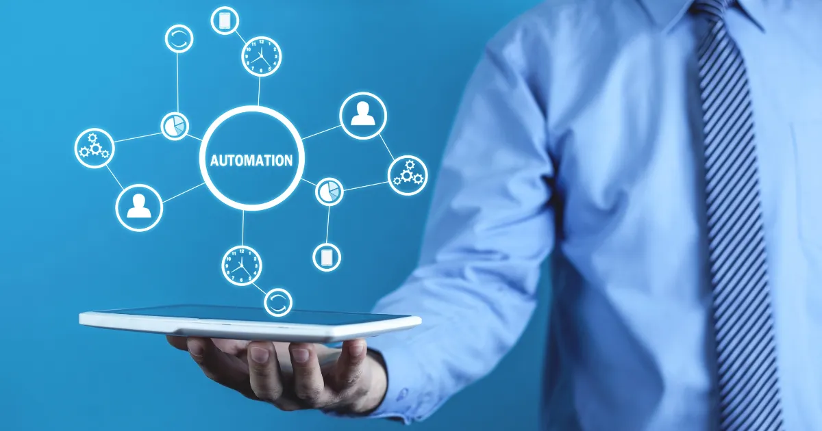 Business professional holding a tablet with a digital hologram showing automation icons connected in a network, symbolizing workflow automation and efficiency.