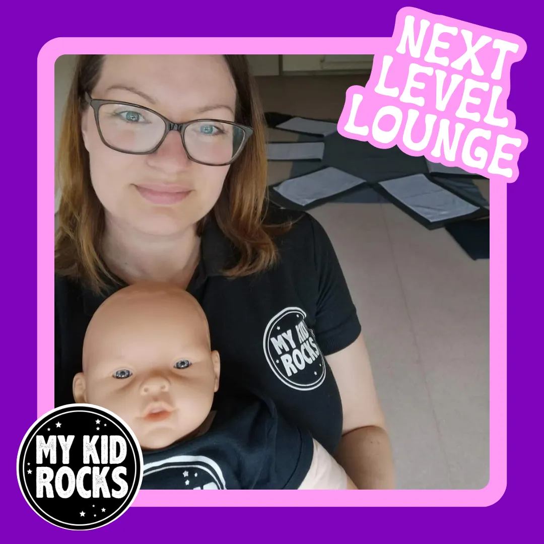 Angela Laverick, holding a doll baby, both in My Kids Rocks tops. 