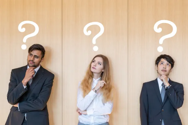 Three people in business clothes standing in a row, each with a hand on their chin and a question mark above their head