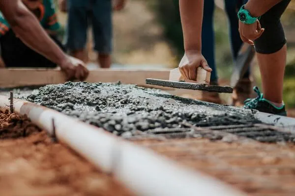 People collaborating on a concrete walkway, symbolizing the effort of launching a business from the ground up.