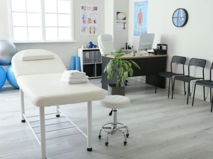 Modern chiropractic office in Dunwoody with an adjustment table, exercise balls, and ergonomic setup for patient care