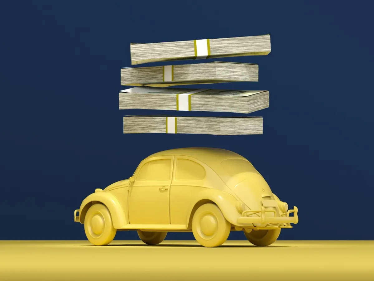 Yellow VW Beetle supporting a stack of cash