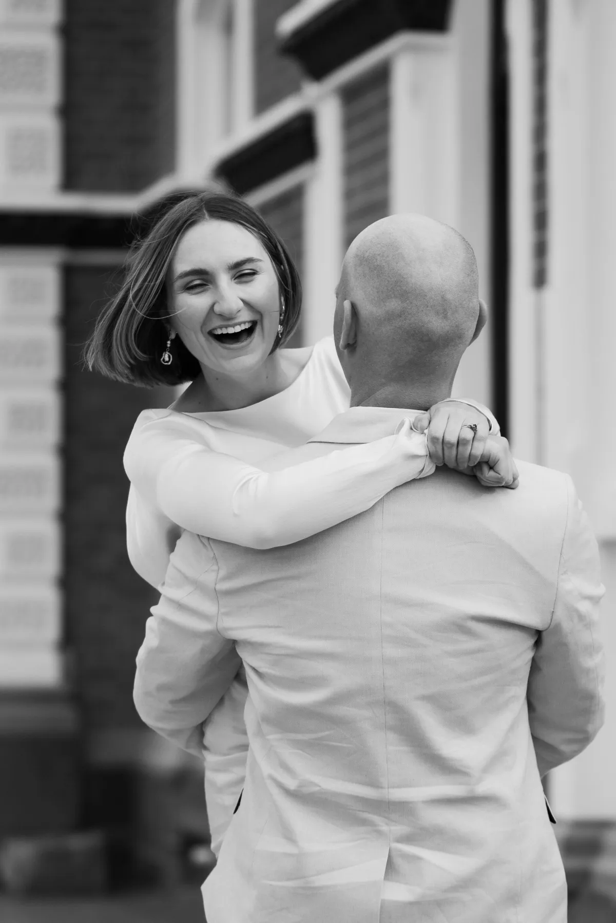 Couple dancing in cathedral square in bridal party posing with the bride laughing