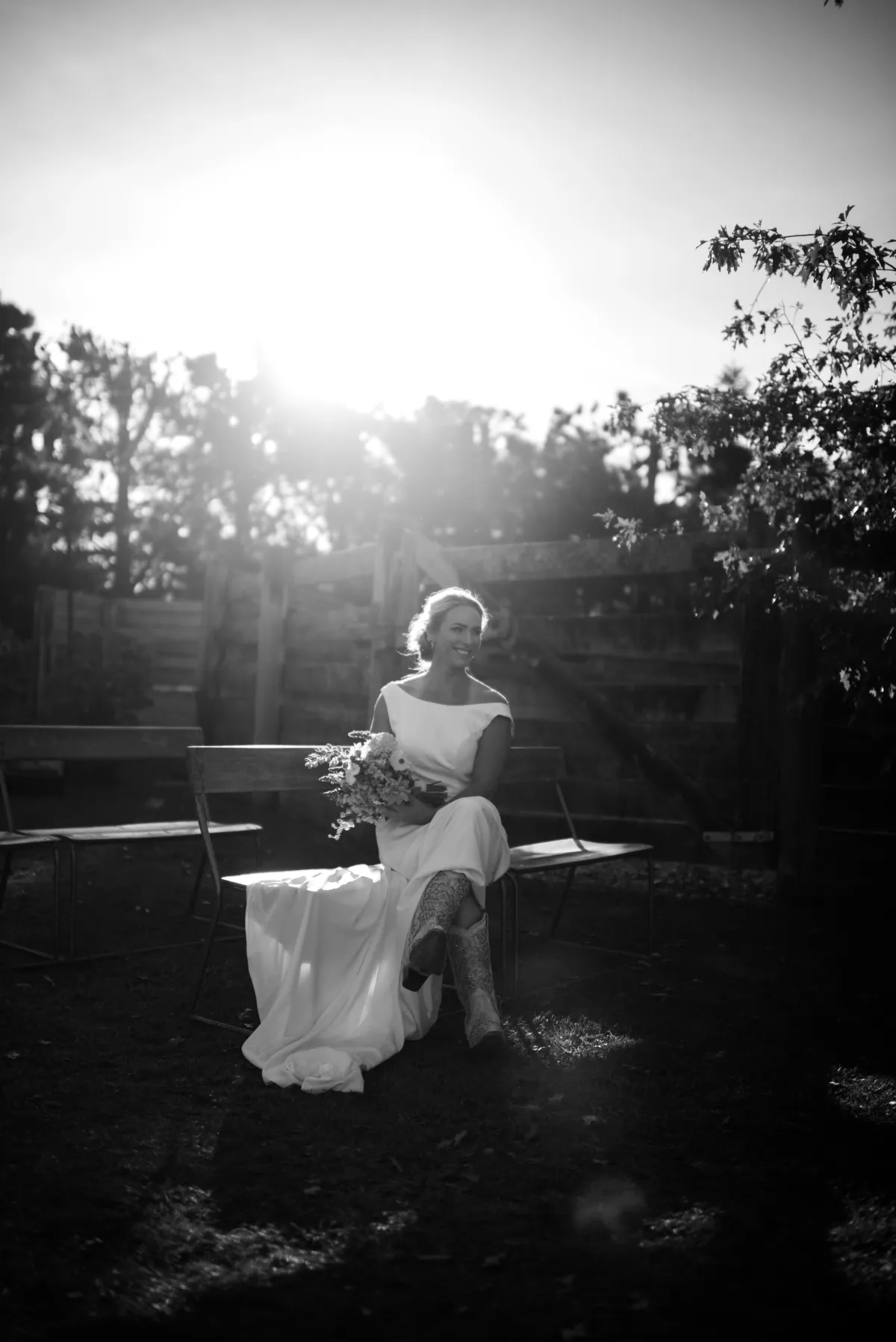 Black and white portrait of a bride sitting at sunset