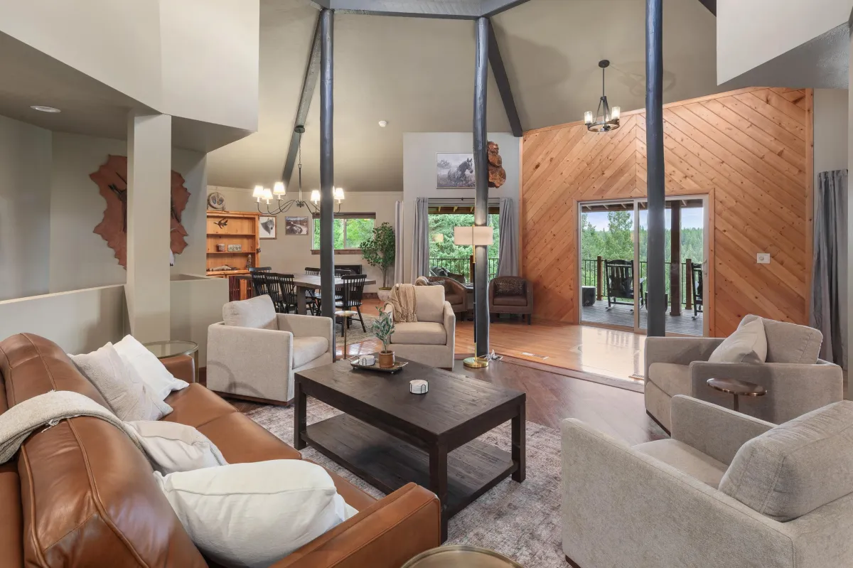 Spacious main floor living area with cathedral ceilings and open access to the chef-inspired kitchen, formal dining area, and covered wrap-around porch with river and mountain views.
