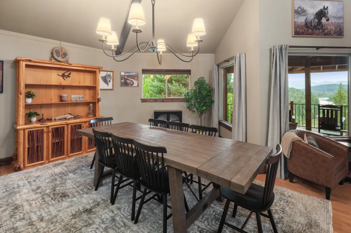 Formal Dining Area – Spacious dining table with seating for large groups, surrounded by windows framing mountain views. Perfect for family meals, celebrations, or holiday gatherings in this luxury Montana lodge.