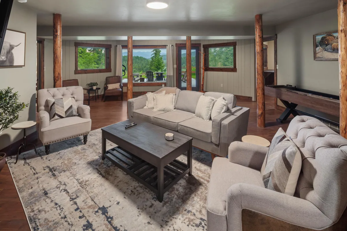 Cozy Living Room on lower level with Natural Light. This  comfortable living area is filled with natural light and stylish furnishings. Perfect for relaxing after exploring Glacier National Park  or Whitefish Resort, with plenty of seating for group gatherings.