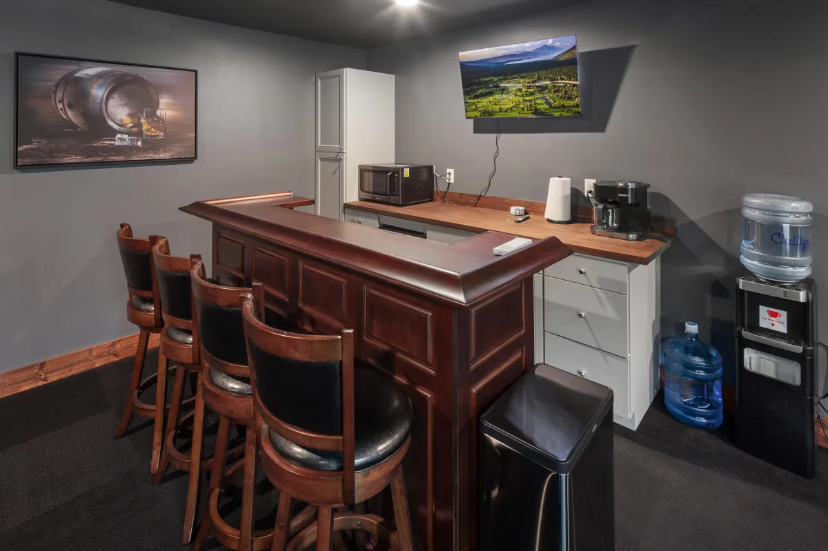 Convenient bar area at the back of the media room with counter seating, mini fridge, and beverage station. Ideal for enjoying snacks and drinks while watching movies or sporting events.