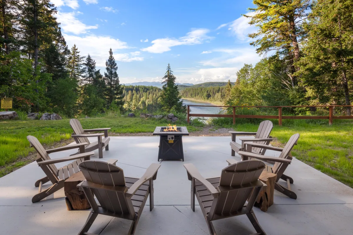 Outdoor patio with Adirondack chairs and fire pit table, offering beautiful views of the Flathead River and surrounding forest (no river access). Ideal for evening conversations, hot cocoa, and toasting marshmallows under Montana’s big sky.