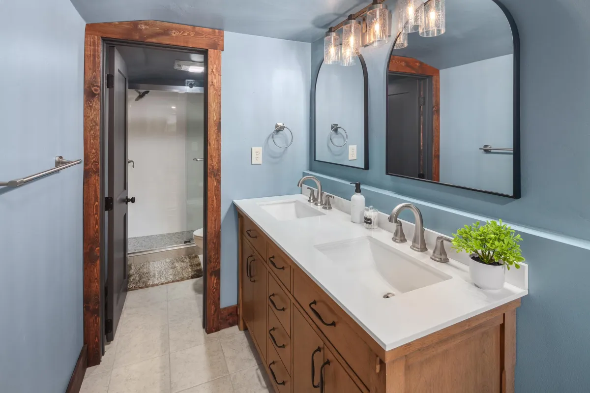 Bright bathroom with rustic wood accents, dual vanities, and easy access to the walk-in shower. A comfortable space to get ready for a day of adventure or unwind after exploring Glacier National Park.