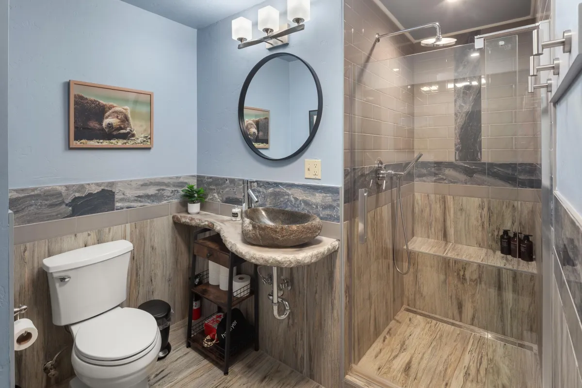 Elegant full bathroom with walk-in shower, rustic wood accents, and premium fixtures. Conveniently located near the Buffalo bedroom in this 6BR/5BA Montana vacation rental minutes from Glacier National Park.