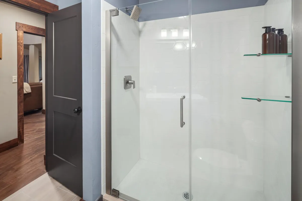 Bright bathroom with spacious glass walk-in shower and premium fixtures. This beautiful Montana vacation rental is close to Glacier National Park, Whitefish Resort, great dining, and outdoor adventures.