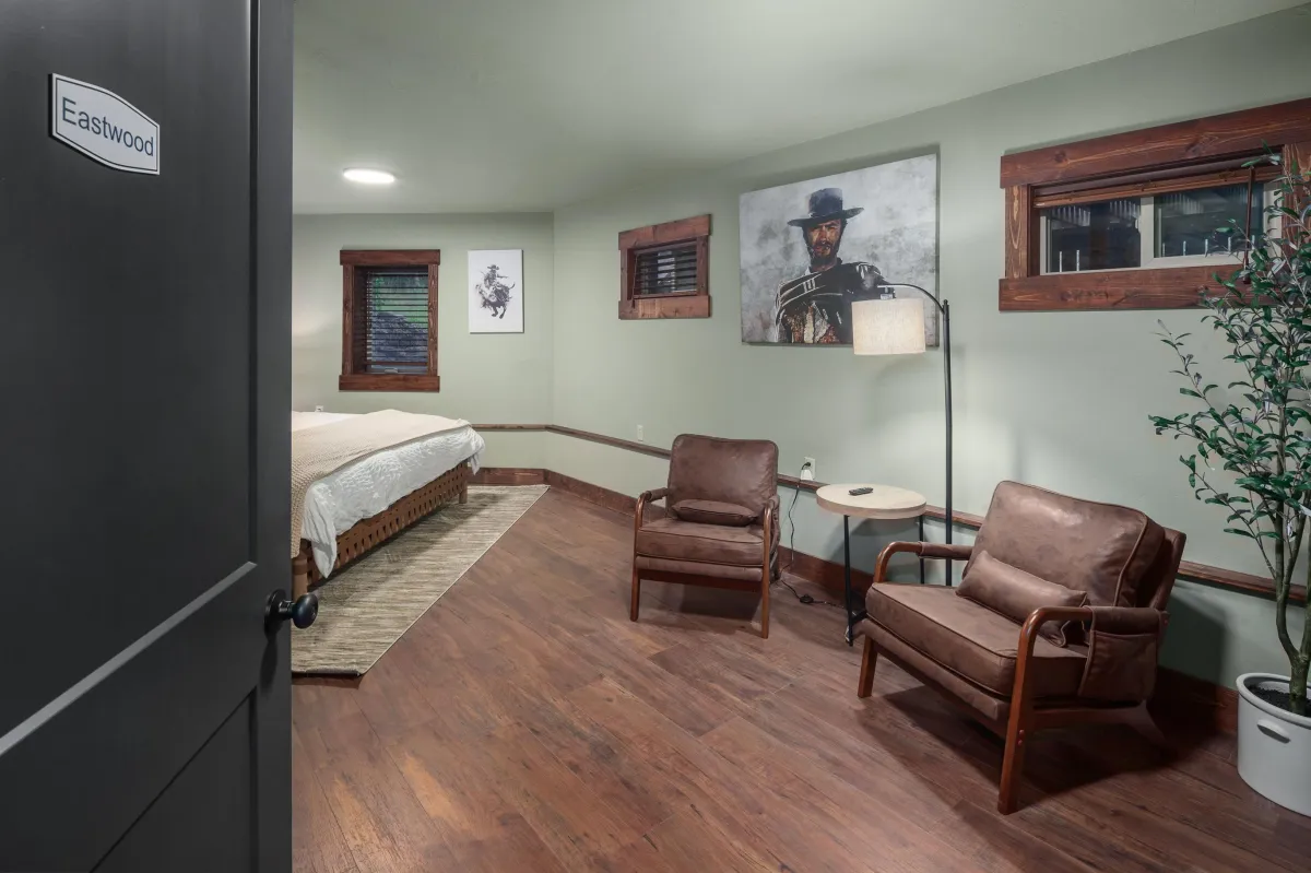 Eastwood room with king bed, cozy seating area, smart TV, and a stylized painting of the legend himself. Ideal for relaxing after exploring Montana’s Rocky Mountains and Glacier National Park.