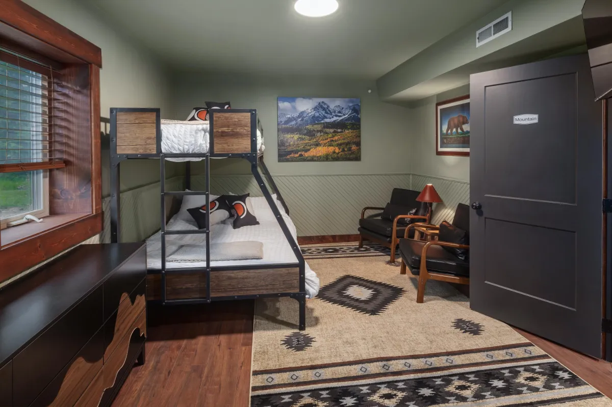 The Mountain bedroom with twin-over-full bunk bed, rustic furnishings, and mountain art is perfect for kids of all ages in this luxury Montana lodge near Glacier National Park.