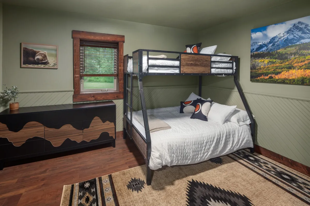 The Mountain bedroom with twin-over-full bunk bed, rustic decor, and mountain landscape art also has a Smart TV and plenty of space to stretch out. Ideal for kids of all ages in this luxury Montana lodge just minutes from Glacier National Park.