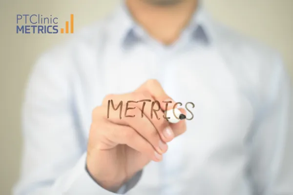 Man in blue shirt writing metrics in black ink