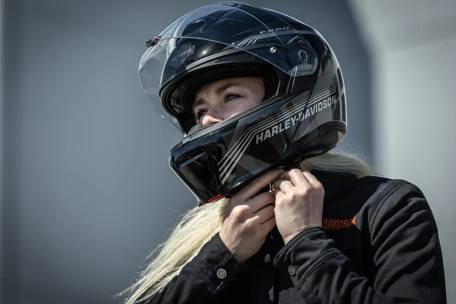woman putting on motorcycle helmet