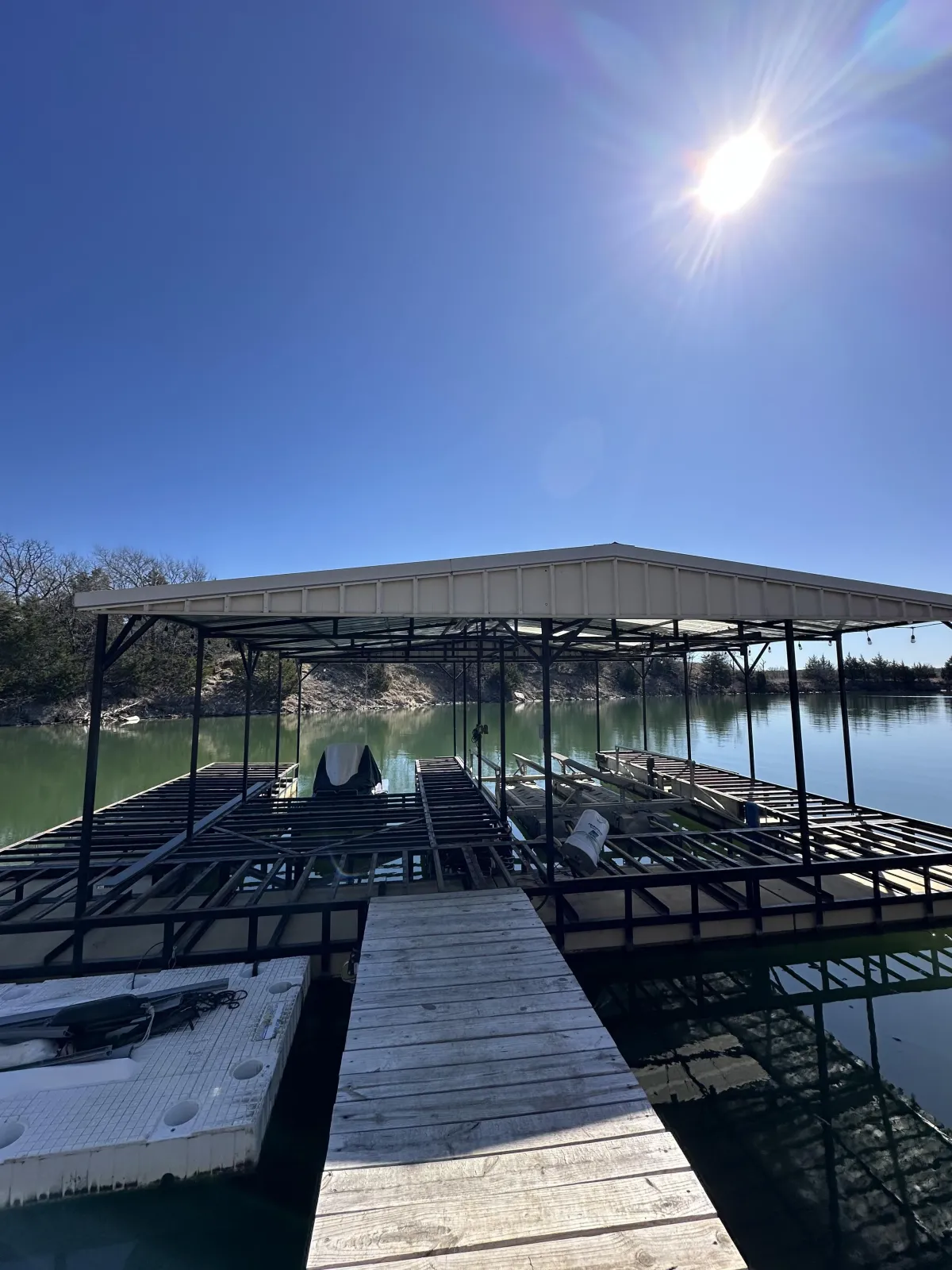 Boat-dock steel frame with metal roof — lake installation.