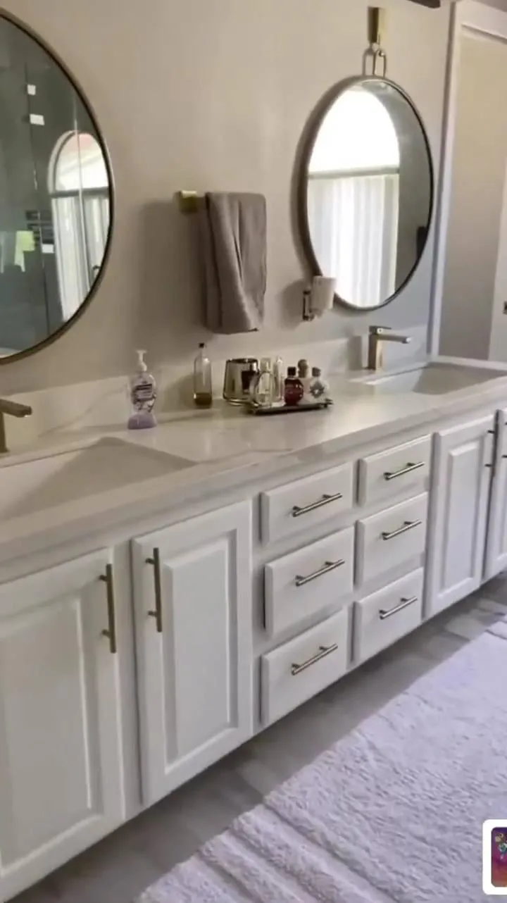 Freestanding soaking tub with floor-mounted faucet and designer tile wall.
