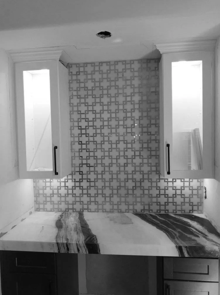 Modern spa-style bathroom remodel with frameless shower and natural stone tile.