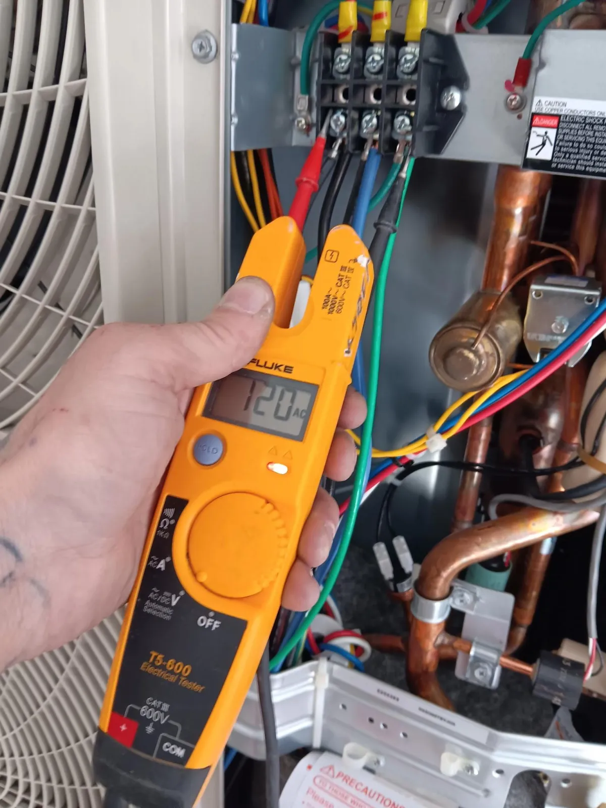 Mountain Man Electric electrician using a multimeter to test electrical connections for safety and functionality in Aurora
