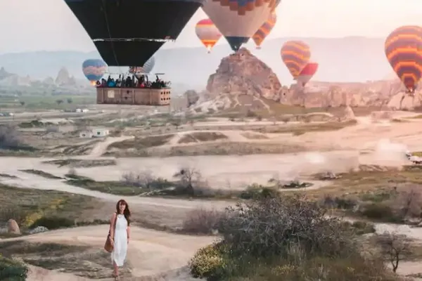 A woman standing under hot air balloons in Turkey