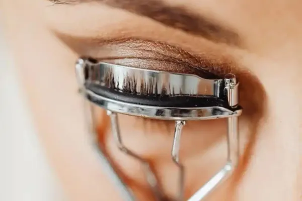 A woman using an eyelash curler