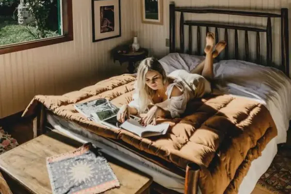 A woman lying on her bed reading