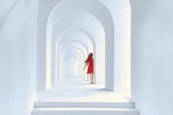 A woman walking through a white corridor