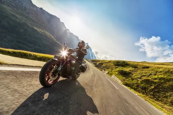 “Motorcycle leaning into a mountain curve at sunset on Tail of the Dragon.”