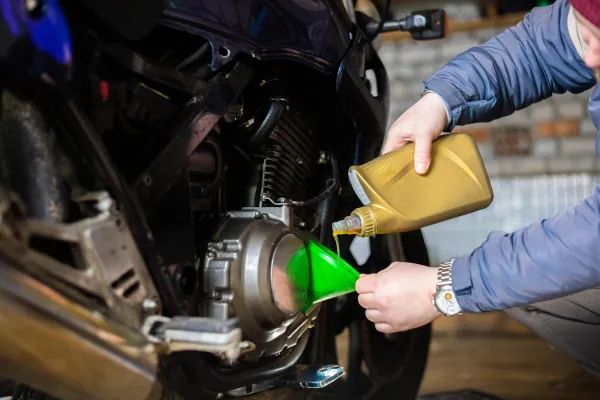 “Oil being poured into a motorcycle engine during an oil change.”