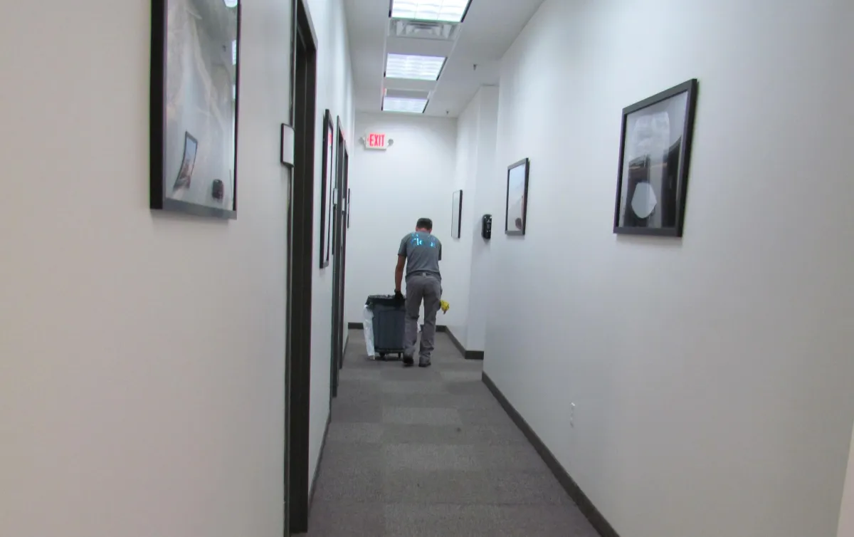 A3D Services employee pushing trash bin down a spotless commercial hallway — showcasing professionalism and holistic facility care.