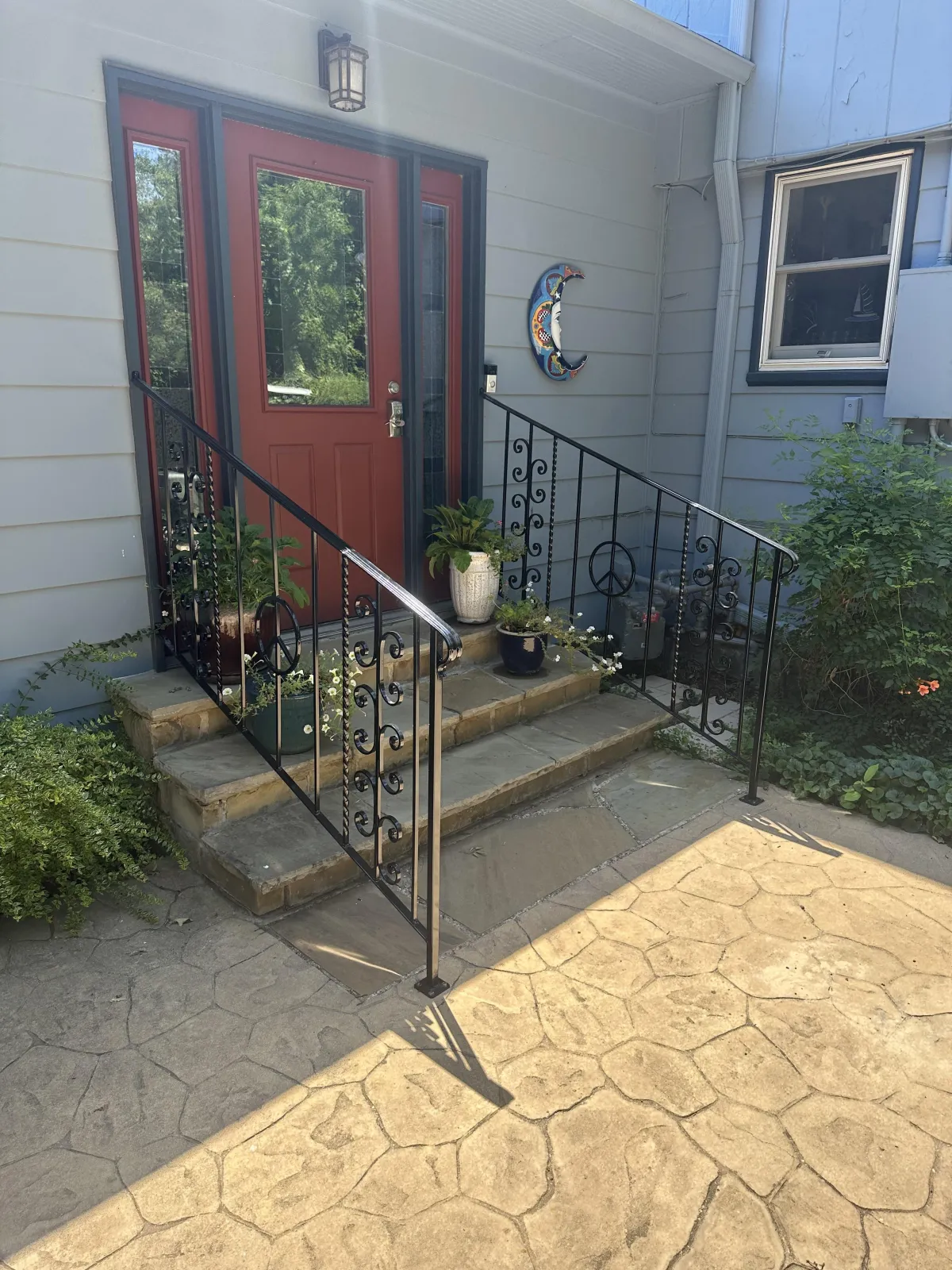 Welded porch railings with decorative scrolls — front steps.