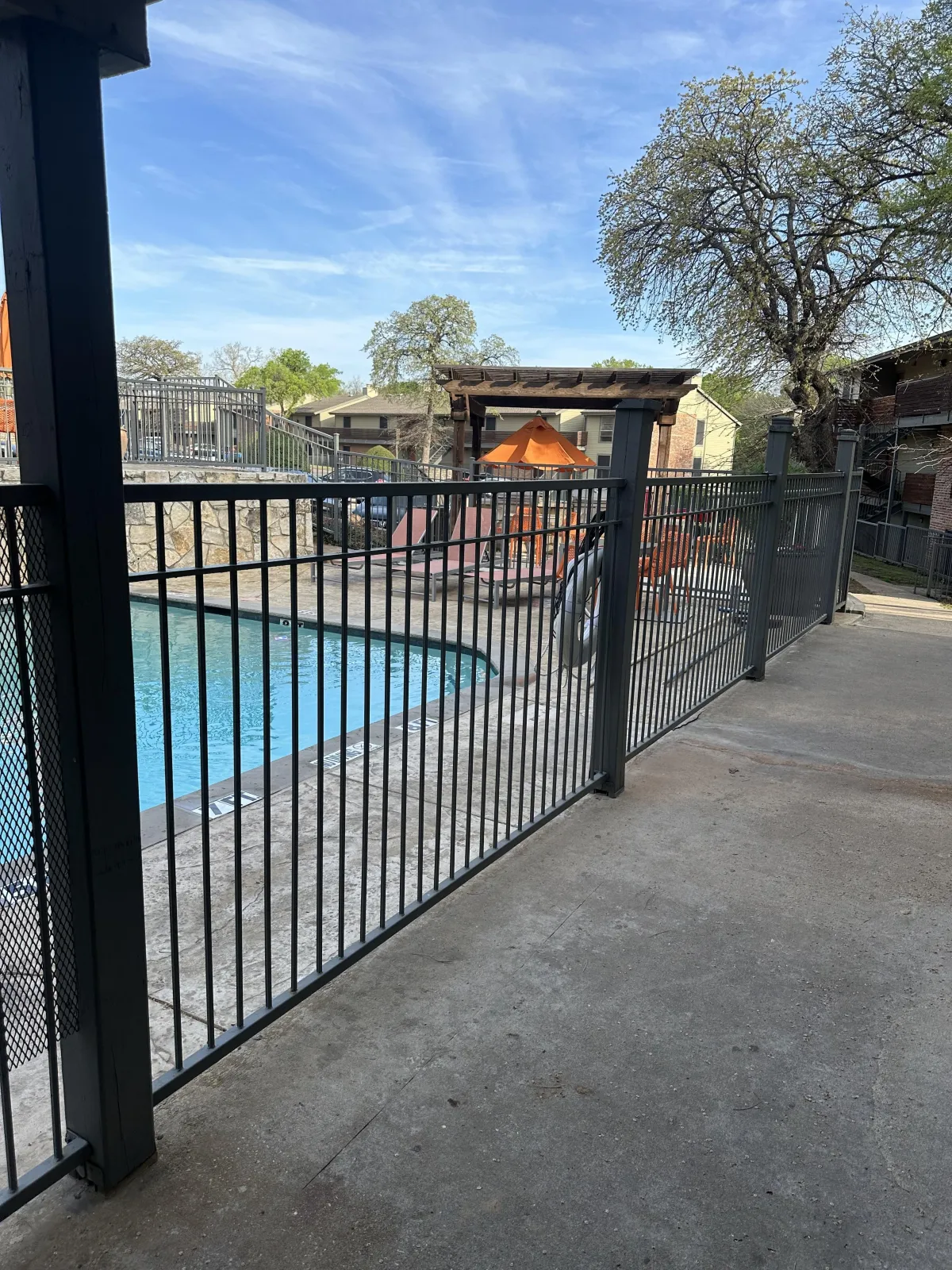 Powder-coated steel pool perimeter fence — apartment/community area.
